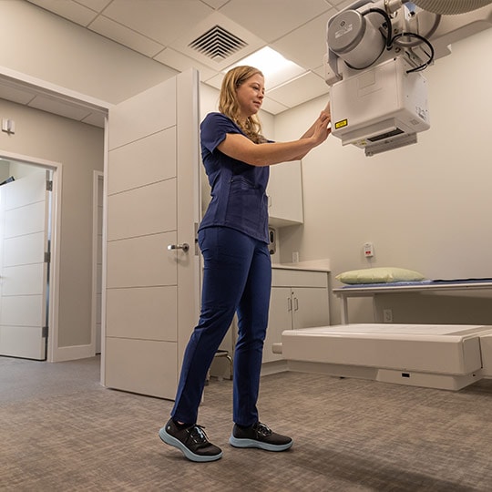 woman in scrubs operating medical equipment